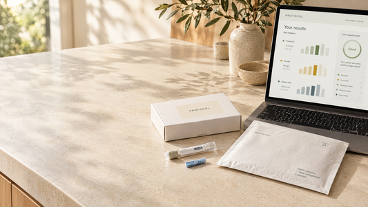At-home blood test kit beside a laptop showing results